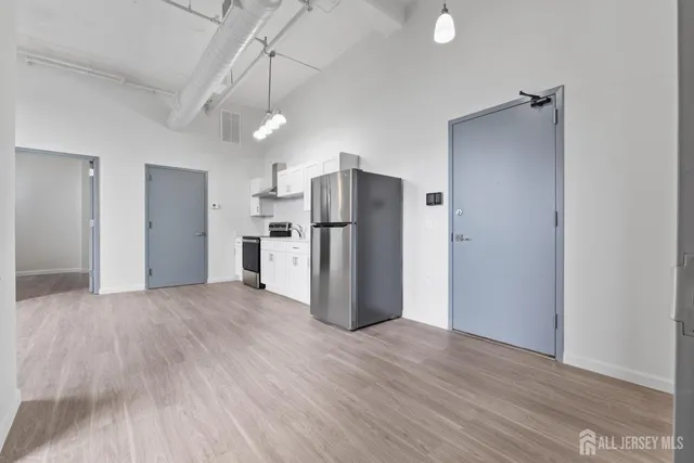 an empty room with wooden floor closet and windows