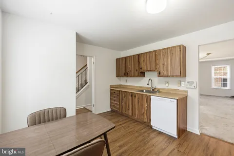 a kitchen with stainless steel appliances granite countertop a microwave a stove a sink dishwasher and a refrigerator with wooden floor