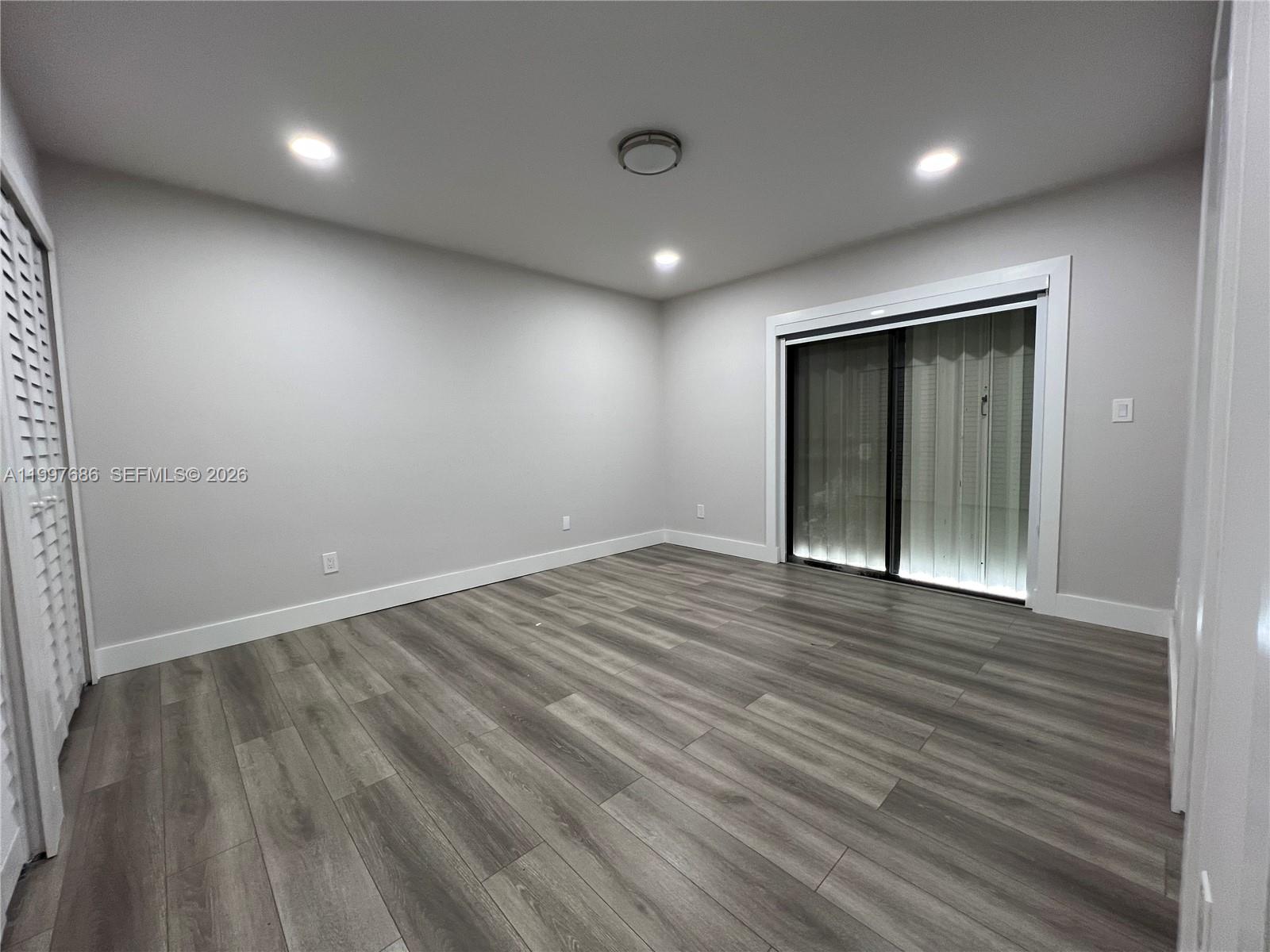 3826 Southwest 107th Avenue, Unit 22 Miami, FL 33165 - Photo 14 of 18 an empty room with wooden floor and windows