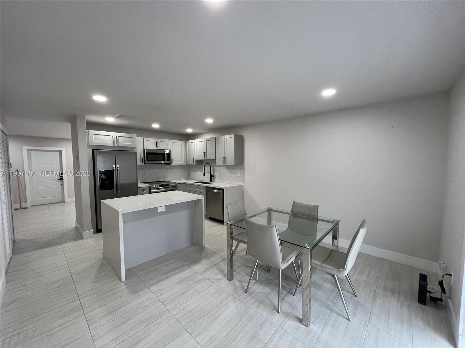 3826 Southwest 107th Avenue, Unit 22 Miami, FL 33165 - Photo 3 of 18 a kitchen with a table and chairs in it