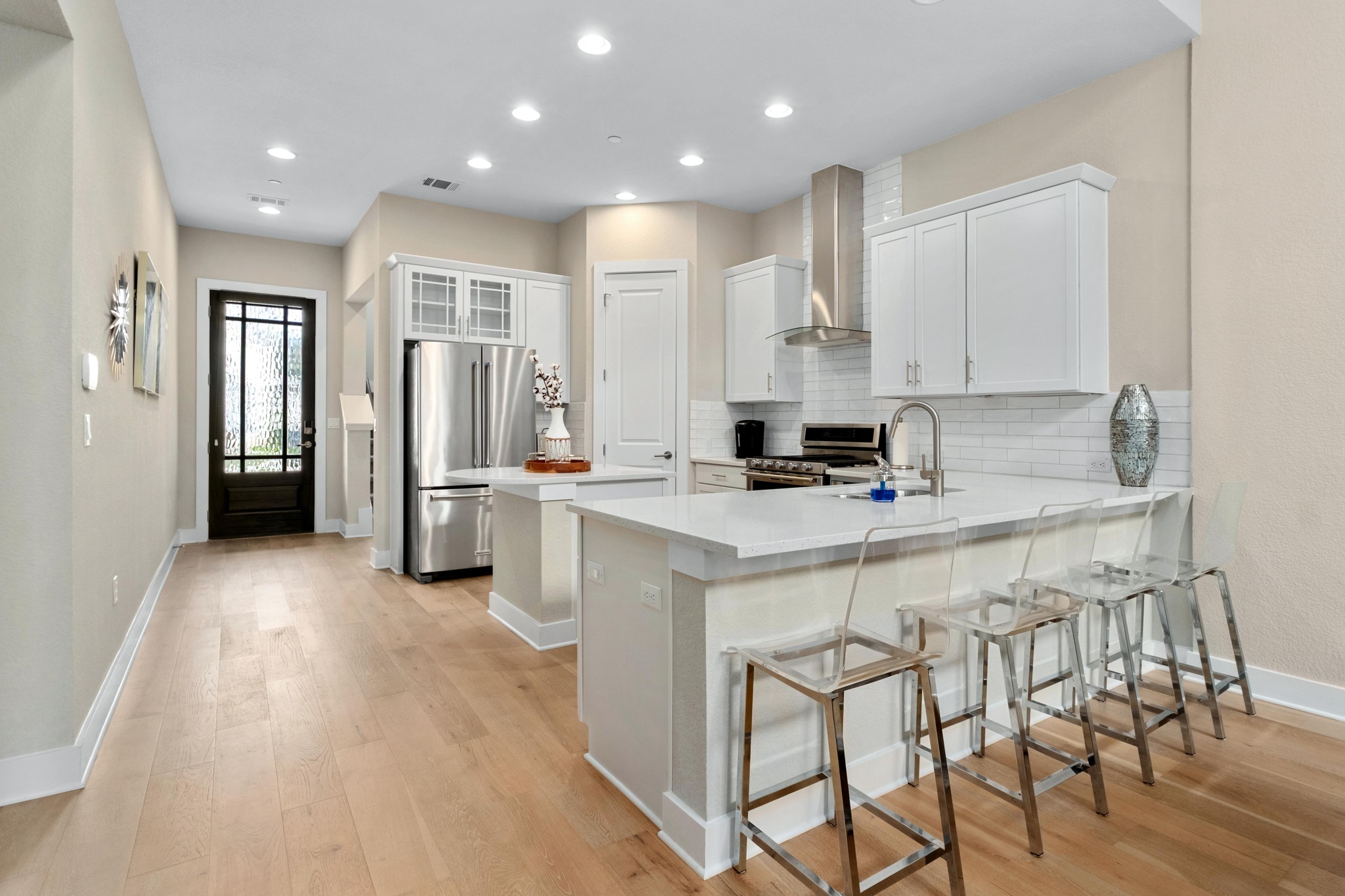 4323 Spicewood Springs Road, Unit 2 Austin, TX 78759 - Photo 3 of 30 Kitchen with white cabinets, a kitchen bar, stainless steel appliances, a kitchen island, and a peninsula