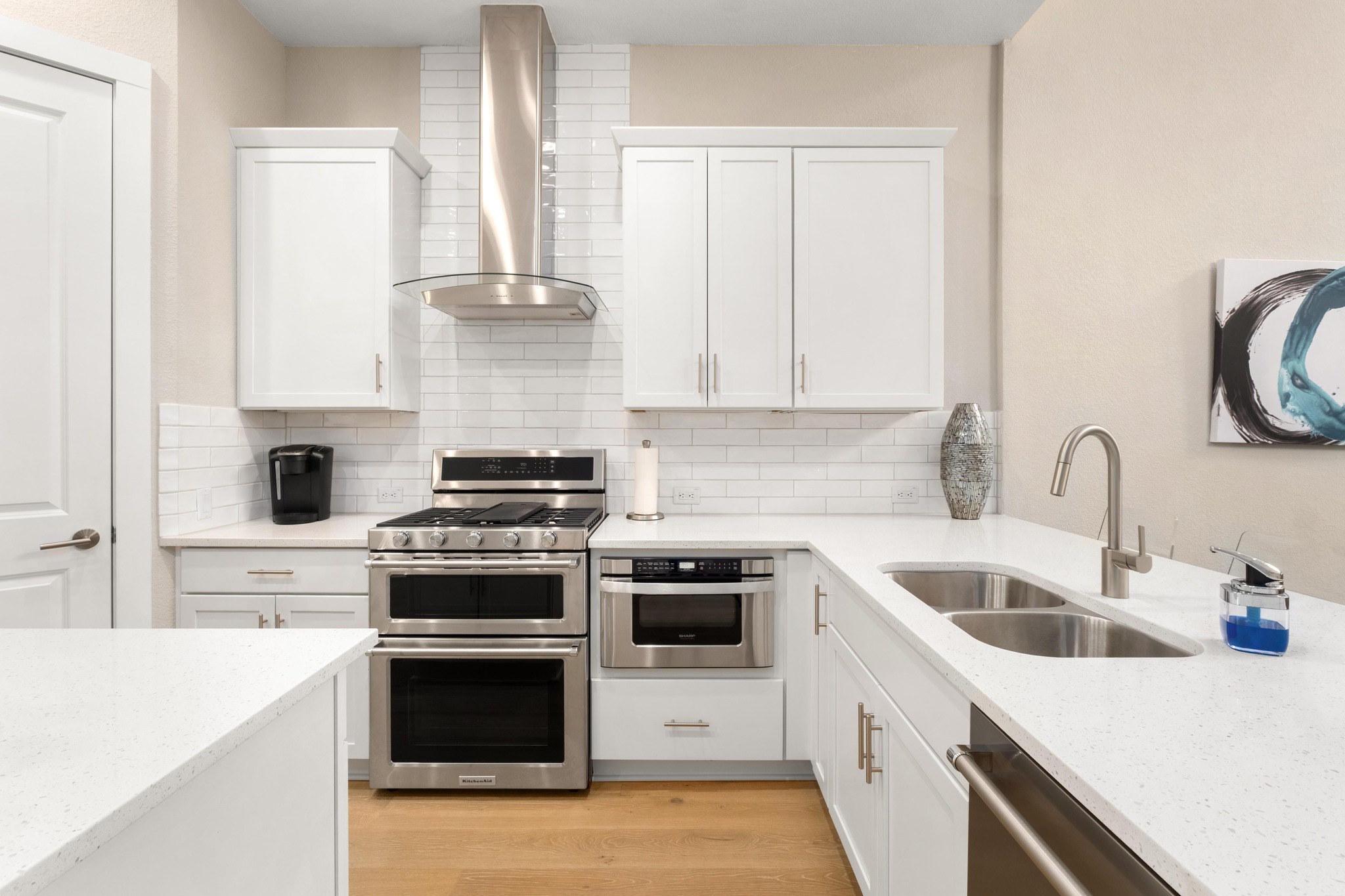 4323 Spicewood Springs Road, Unit 2 Austin, TX 78759 - Photo 5 of 30 Kitchen with stainless steel appliances, white cabinets, light stone counters, light wood finished floors, and backsplash
