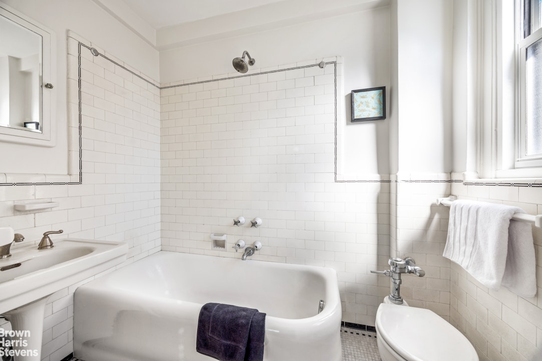 315 East 68th Street, Unit 13F Manhattan, NY 10065 - Photo 7 of 16 a bathroom with a sink and a mirror