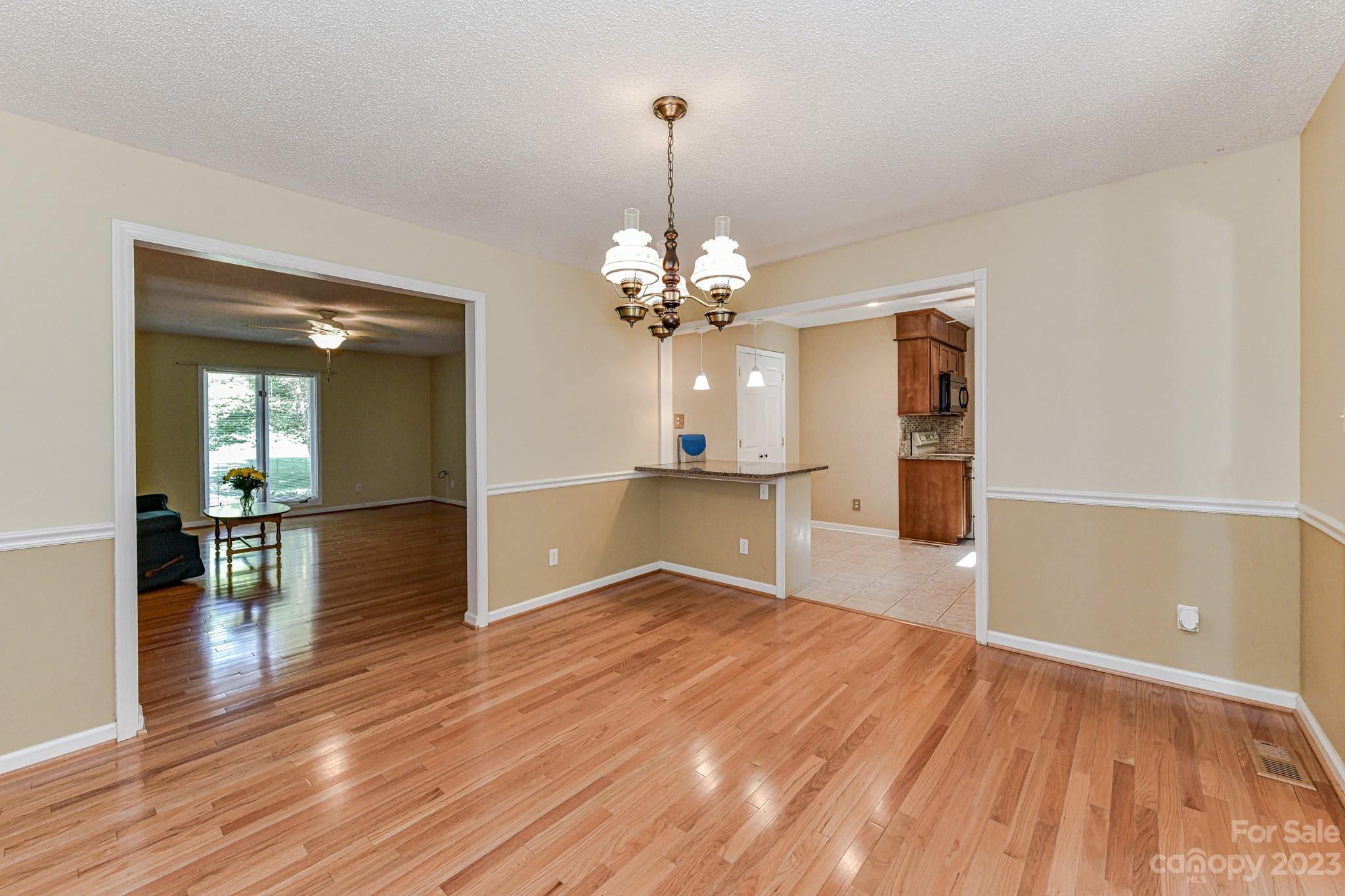 4690 Davidson Road Davidson, NC 28036 - Photo 13 of 29 a view of a room with wooden floor staircase and a kitchen space