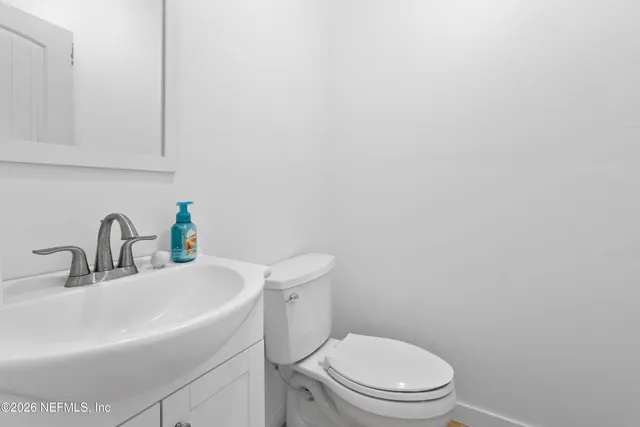 a bathroom with a sink a toilet and mirror