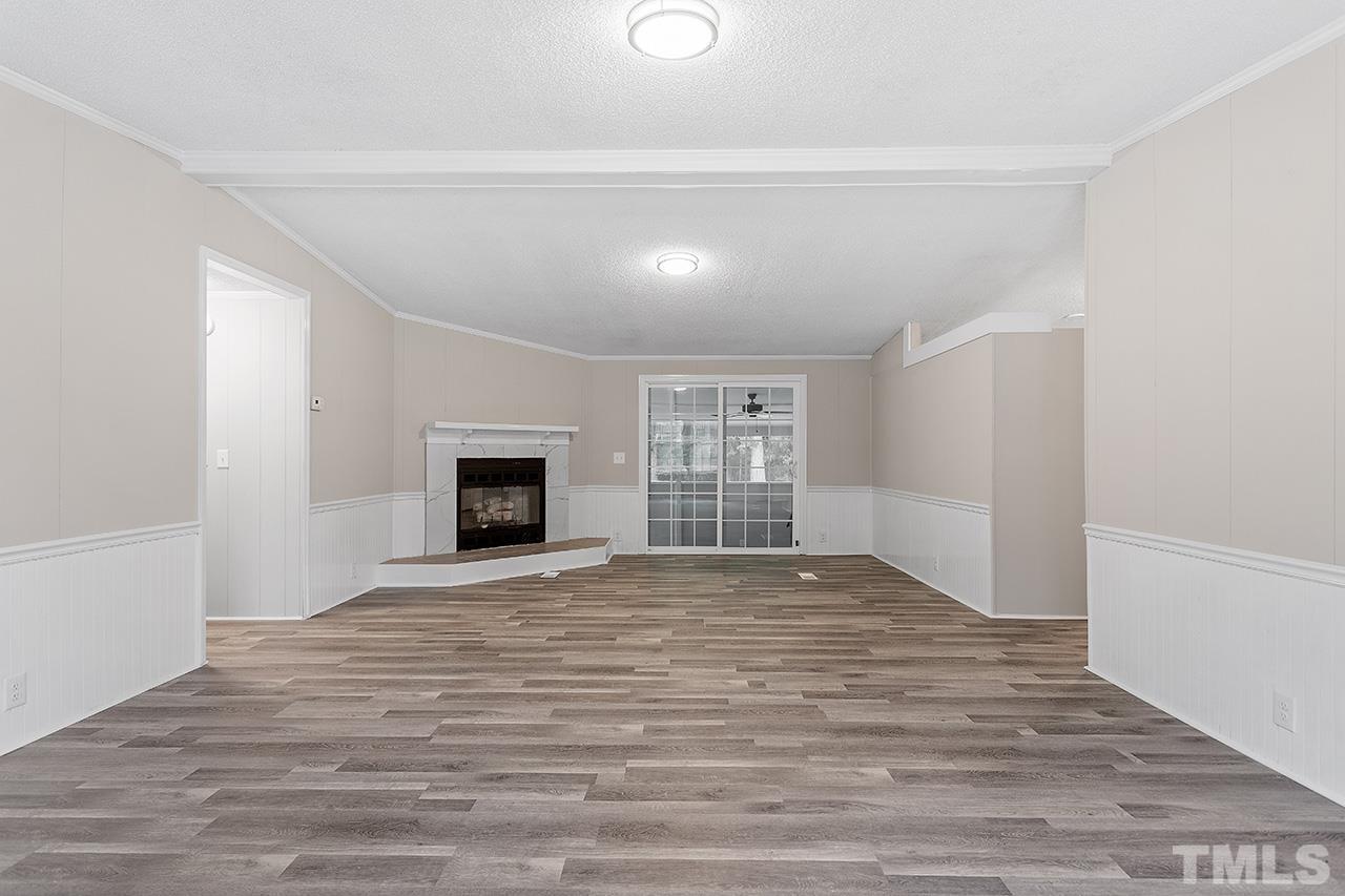 1002 Autry Road Lillington, NC 27546 - Photo 14 of 38 a view of empty room with wooden floor and fireplace