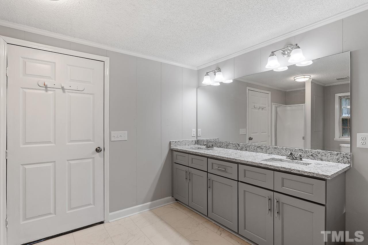 1002 Autry Road Lillington, NC 27546 - Photo 15 of 38 a bathroom with a double vanity sink and a mirror