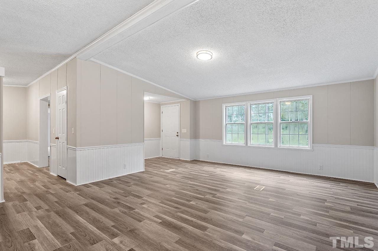 1002 Autry Road Lillington, NC 27546 - Photo 17 of 38 a view of an empty room with wooden floor and a window