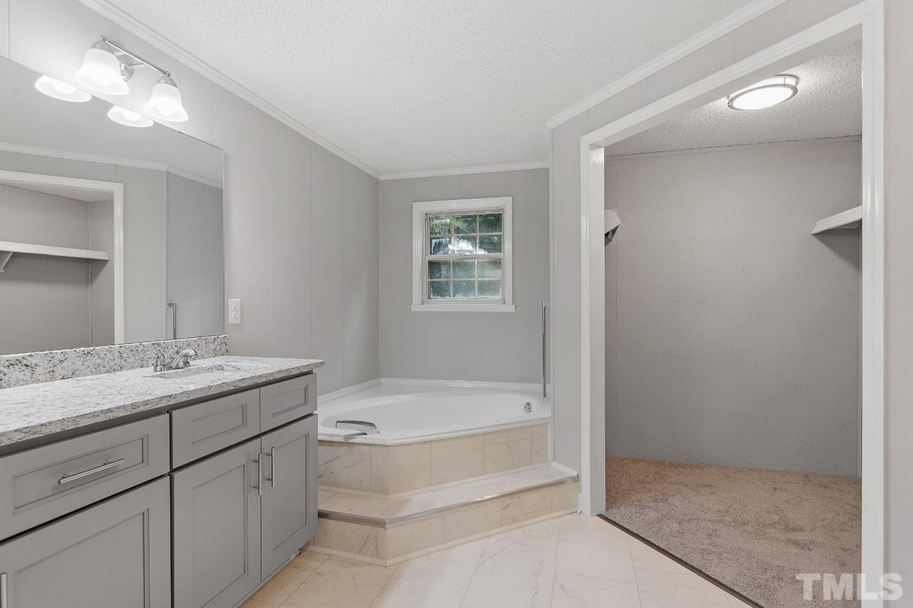 1002 Autry Road Lillington, NC 27546 - Photo 21 of 38 a bathroom with a tub sink and mirror