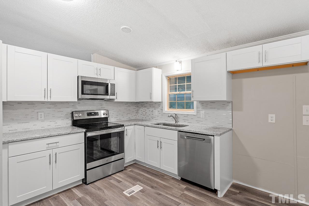 1002 Autry Road Lillington, NC 27546 - Photo 4 of 38 a kitchen with appliances cabinets and a sink