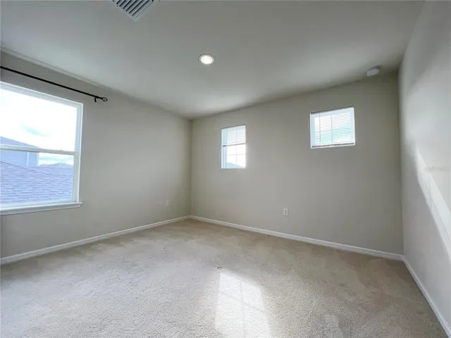 an empty room with windows and closet