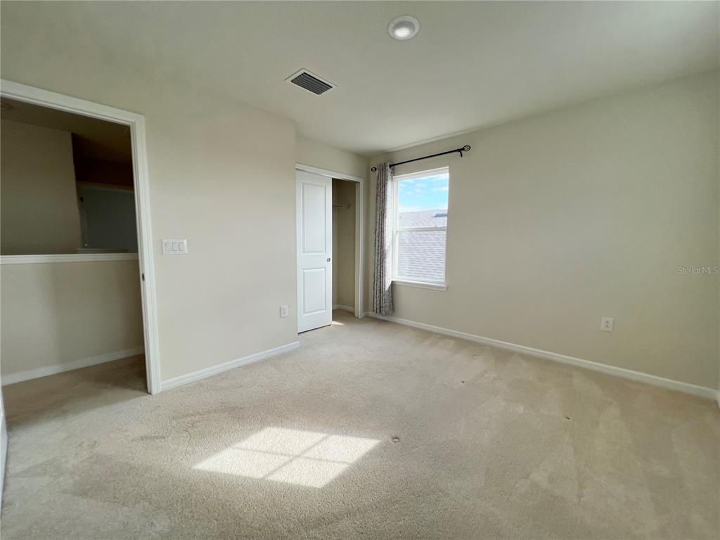 7488 Catania Loop Clermont, FL 34714 - Photo 18 of 31 an empty room with windows and closet
