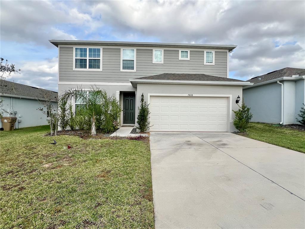 7488 Catania Loop Clermont, FL 34714 - Photo 22 of 22 a front view of a house with a yard and garage