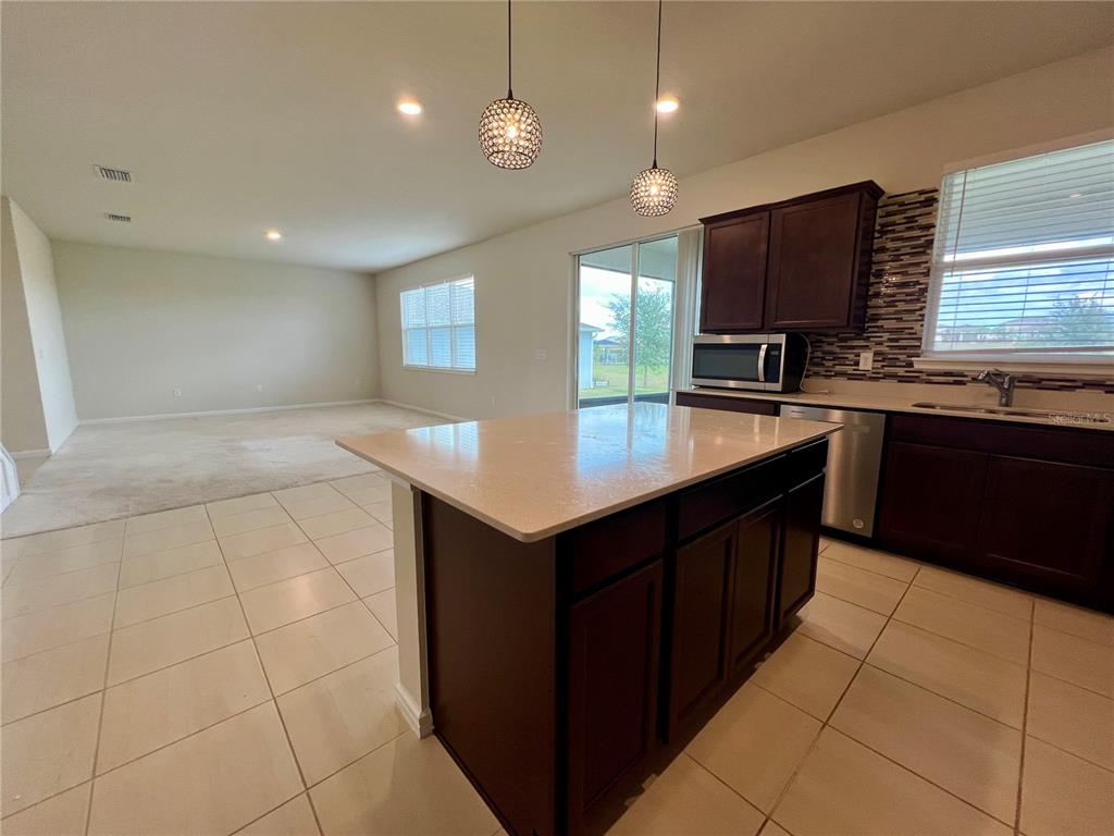 7488 Catania Loop Clermont, FL 34714 - Photo 7 of 22 a kitchen with a sink a counter top space appliances and cabinets