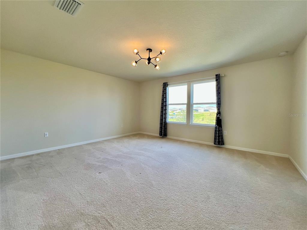 7488 Catania Loop Clermont, FL 34714 - Photo 8 of 31 an empty room with windows and ceiling fan