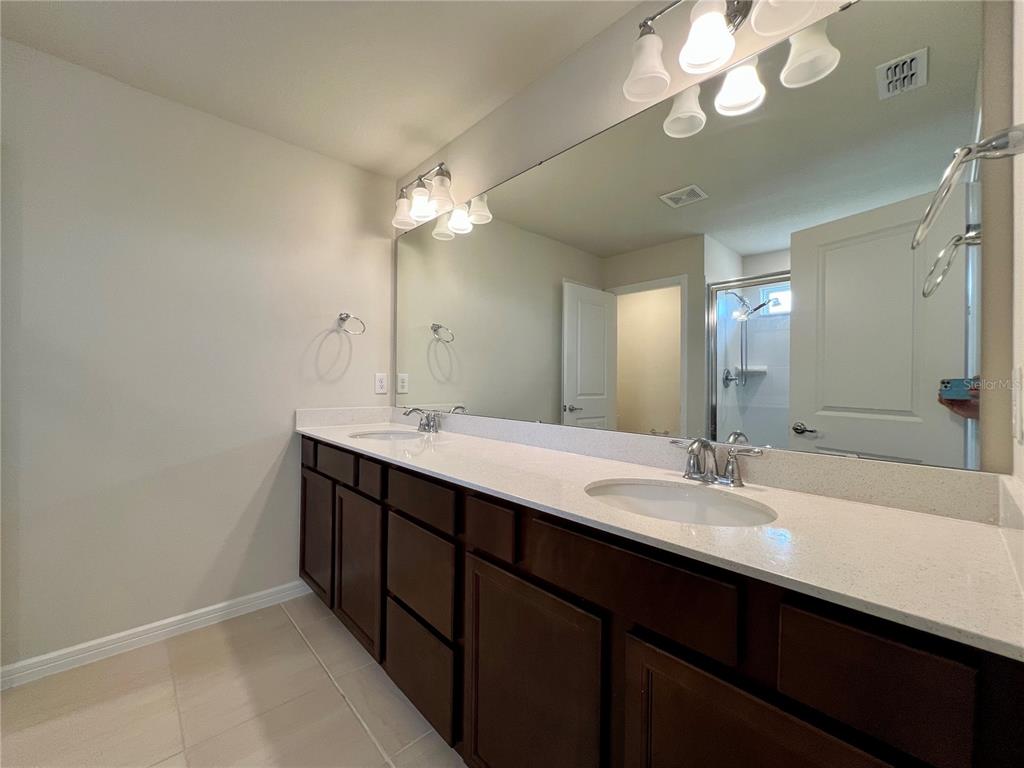 7488 Catania Loop Clermont, FL 34714 - Photo 9 of 22 a bathroom with a double vanity sink and a mirror