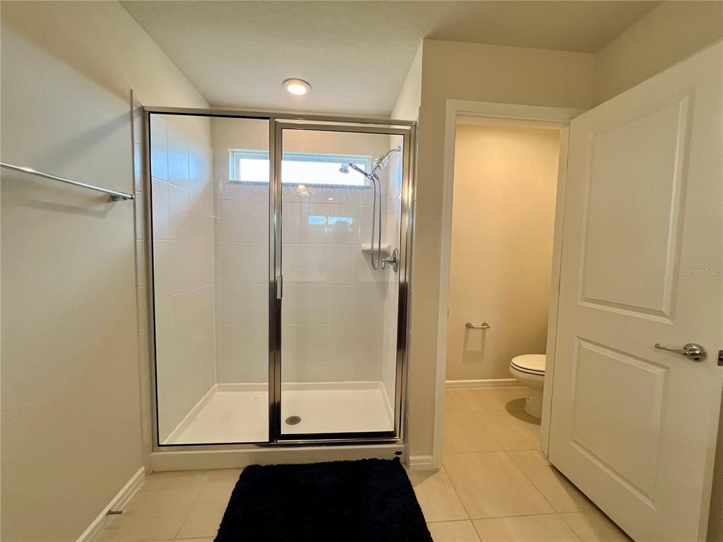 7488 Catania Loop Clermont, FL 34714 - Photo 10 of 22 a bathroom with a glass shower door