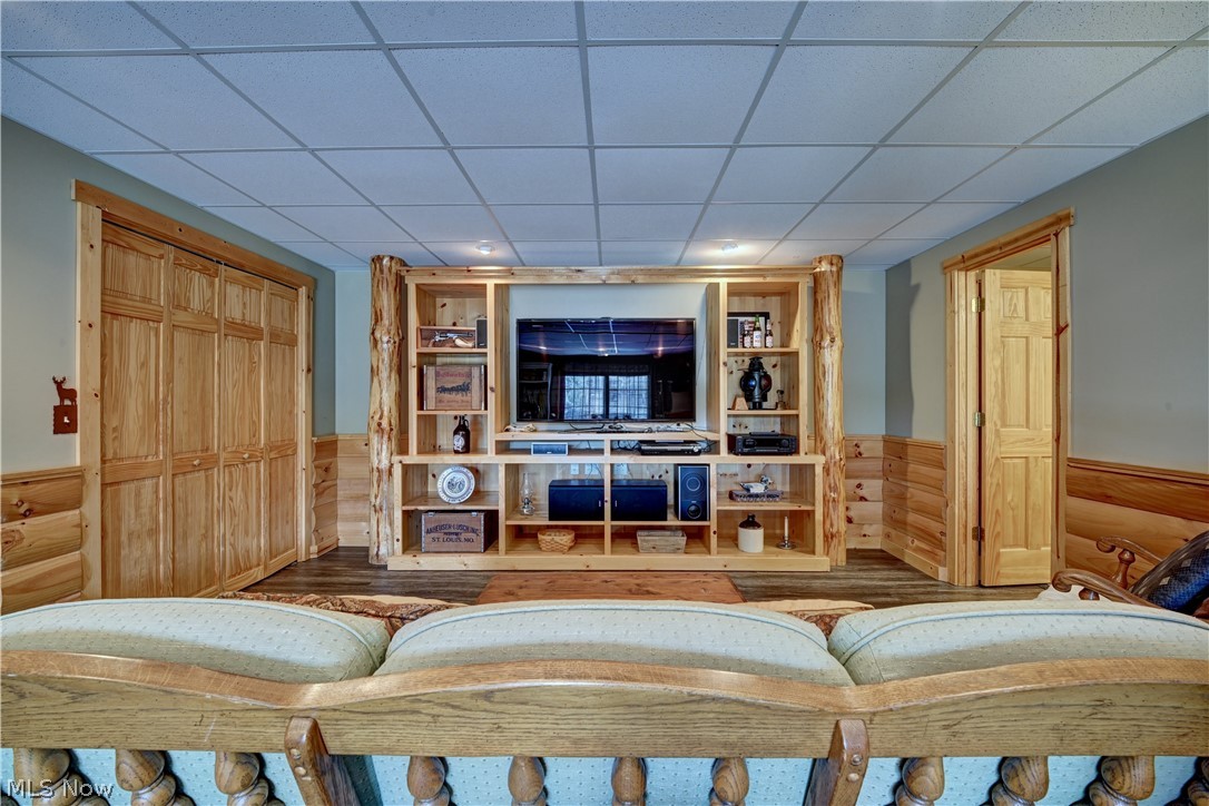 8045 McFadden Road Shreve, OH 44676 - Photo 37 of 45 Living area featuring wainscoting, a paneled ceiling, wood finished floors, and wood walls