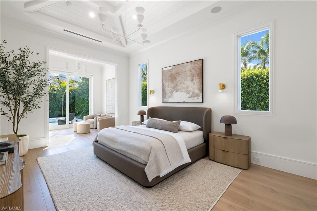 660 Wedge Drive Naples, FL 34103 - Photo 10 of 22 a spacious bedroom with a bed couch and a large window