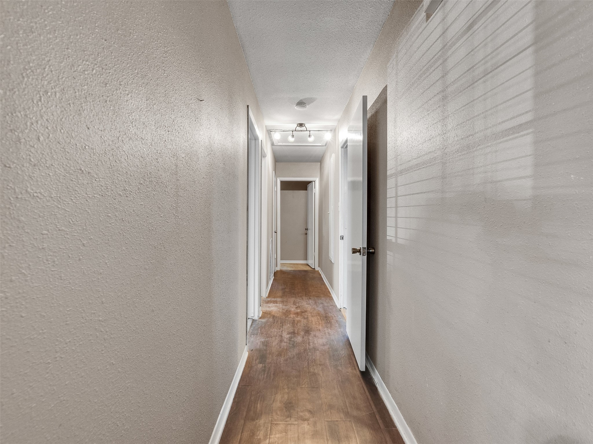 730 Broad Ripple Drive Houston, TX 77336 - Photo 15 of 28 a view of a hallway with wooden floor and a bathroom space