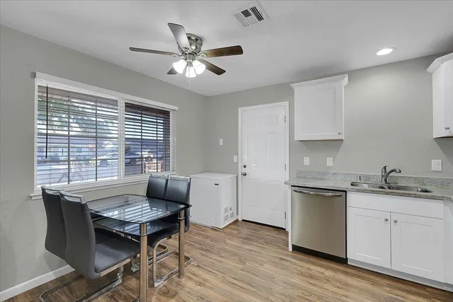 a kitchen with a table chairs and wooden floor