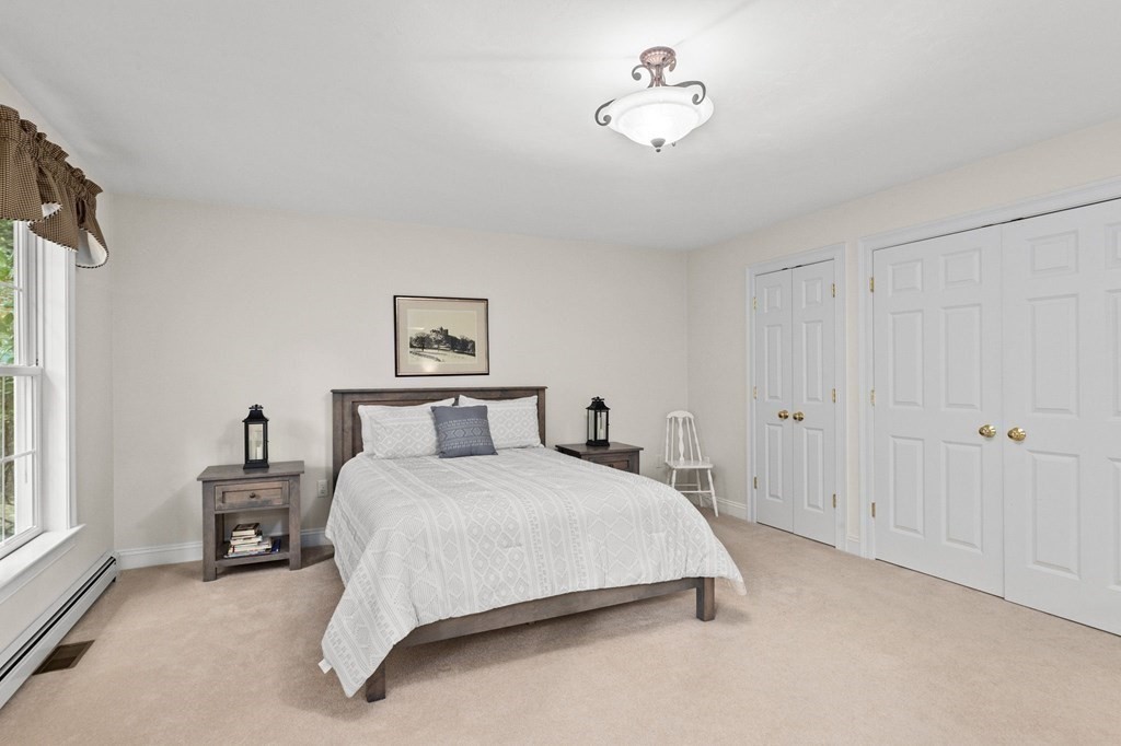 17 Summersweet Circle, Unit 22 Hanover, MA 02339 - Photo 25 of 42 a bedroom with a bed and a chandelier