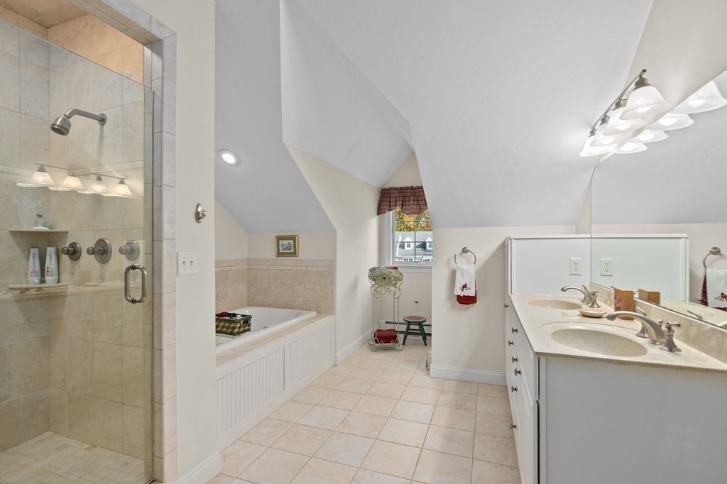 17 Summersweet Circle, Unit 22 Hanover, MA 02339 - Photo 37 of 42 a bathroom with a sink a mirror and a bath tub