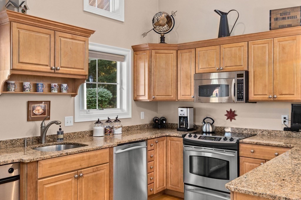17 Summersweet Circle, Unit 22 Hanover, MA 02339 - Photo 7 of 42 a kitchen with stainless steel appliances granite countertop a sink a stove and cabinets
