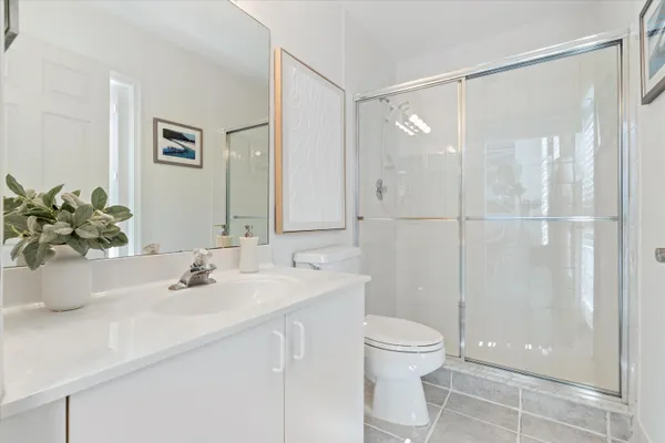 a bathroom with a shower sink vanity mirror and toilet