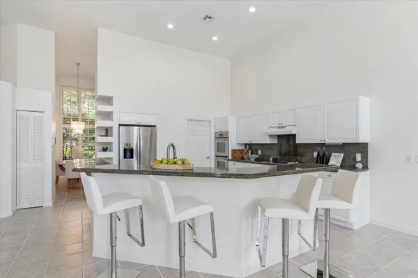 a kitchen with kitchen island granite countertop wooden cabinets and stainless steel appliances