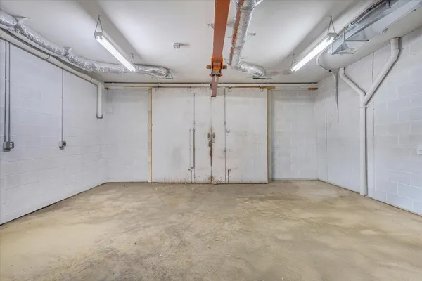 an aerial view of a house with a yard and covered with trees