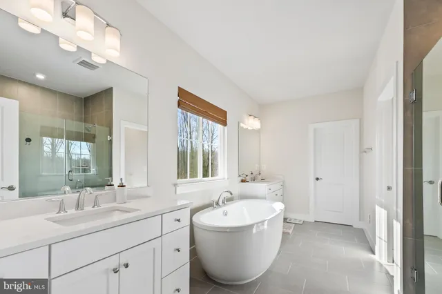 a spacious bathroom with a bathtub sink and mirror