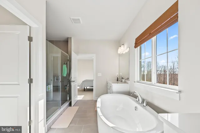 a bathroom with a sink and mirror with bathtub