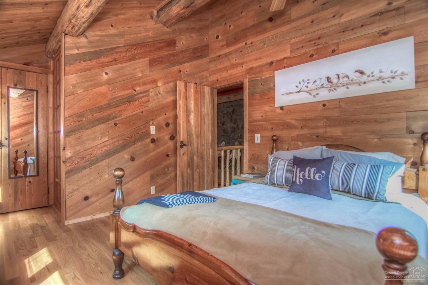 18762 Ridgecrest Road Bend, OR 97703 - Photo 14 of 25 a bedroom with a bed and wooden floor