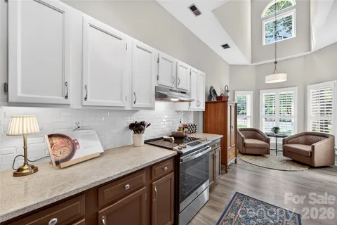 a kitchen with stainless steel appliances granite countertop a sink stove and cabinets