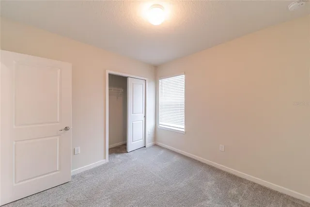 an empty room with windows and closet
