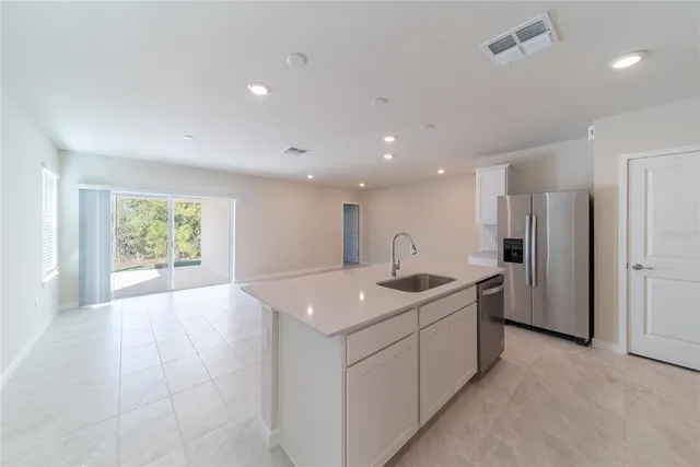 a kitchen with kitchen island a sink stainless steel appliances and cabinets