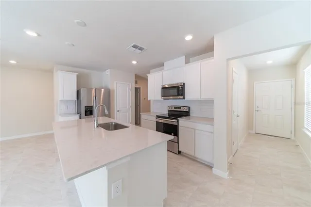 a kitchen with stainless steel appliances a refrigerator sink and stove