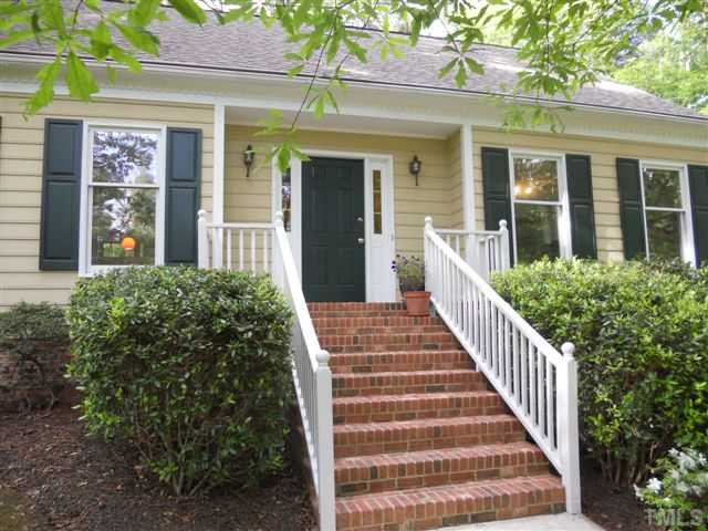 Brick stairs lead to entry of this Pretty Cape Cod.
