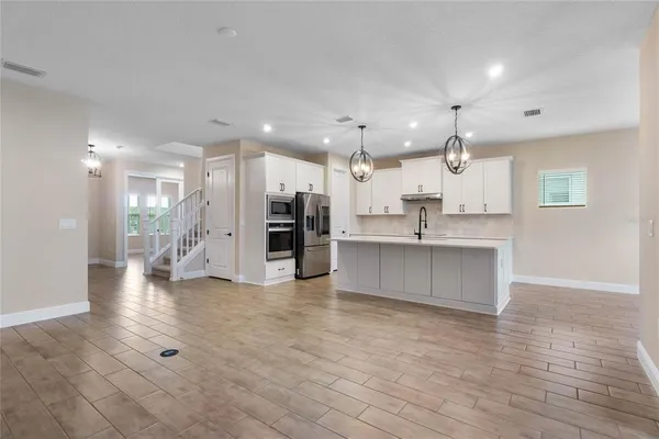 a large kitchen with a large counter top stainless steel appliances and cabinets