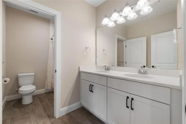 a bathroom with a sink a toilet and a mirror