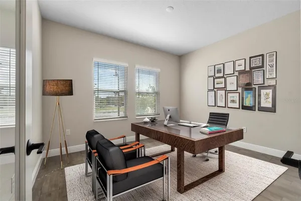 a view of a workspace with furniture and a window