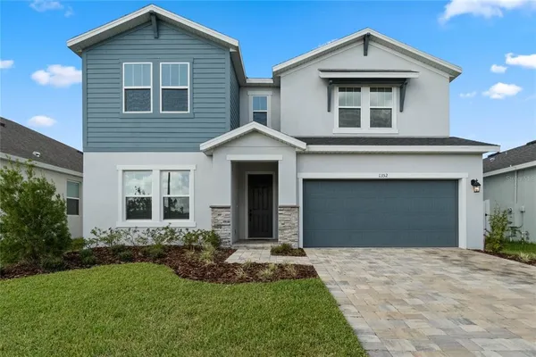 a front view of a house with a yard and garage
