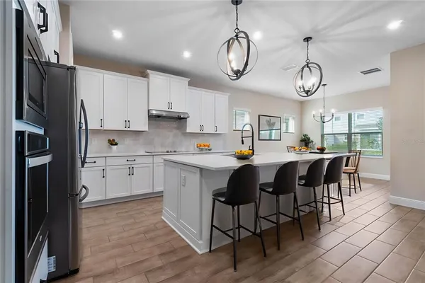 a kitchen with cabinets a sink stainless steel appliances and window