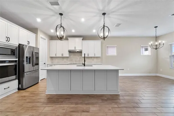 a large kitchen with stainless steel appliances a large island in it