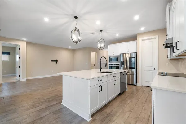 a kitchen with stainless steel appliances kitchen island a sink and a refrigerator