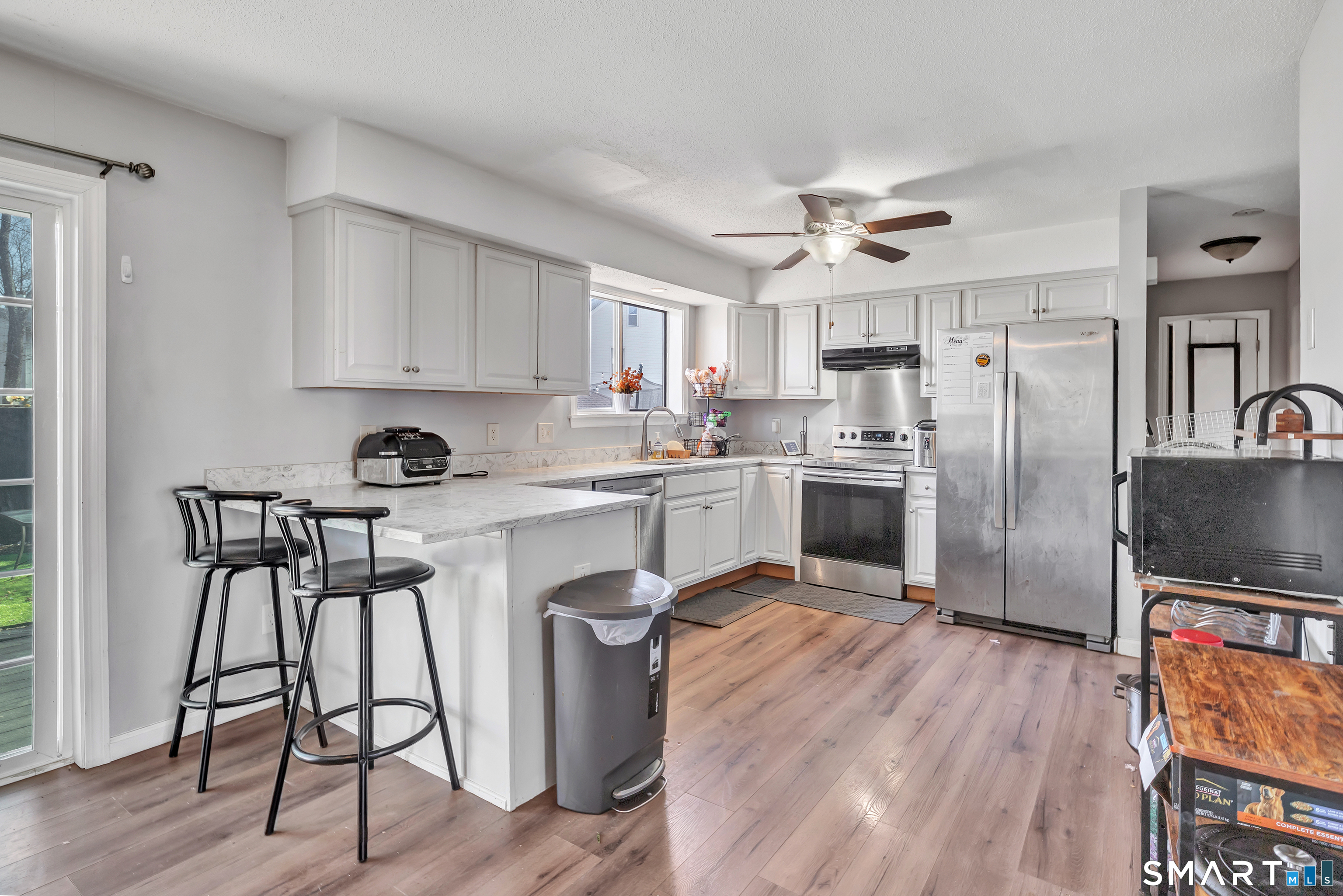 71 Cliff Street Naugatuck, CT 06770 - Photo 15 of 40 a kitchen with stainless steel appliances granite countertop a refrigerator a stove a sink dishwasher and white cabinets with wooden floor