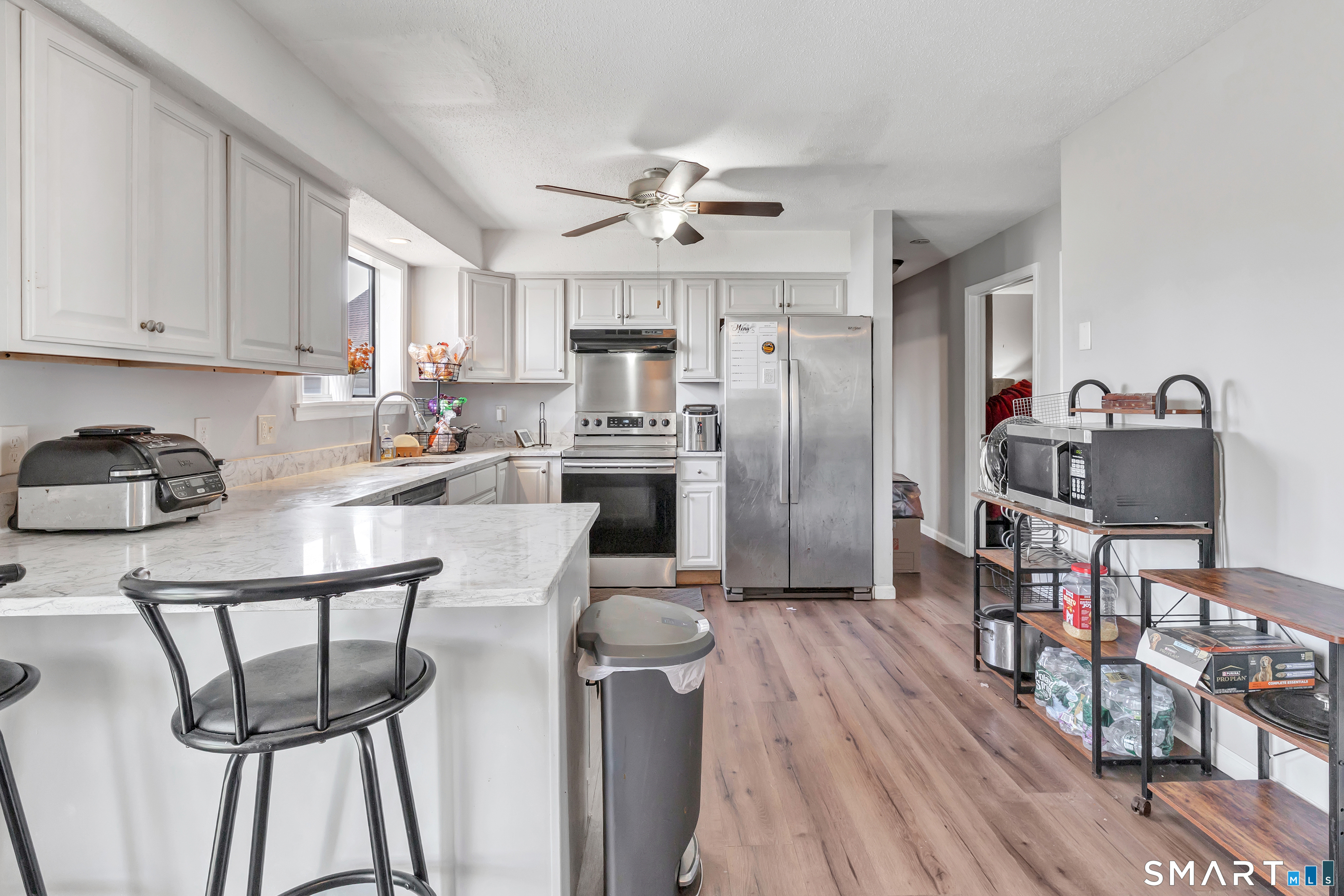71 Cliff Street Naugatuck, CT 06770 - Photo 16 of 40 a kitchen with stainless steel appliances granite countertop a refrigerator a stove a sink dishwasher and white cabinets with wooden floor