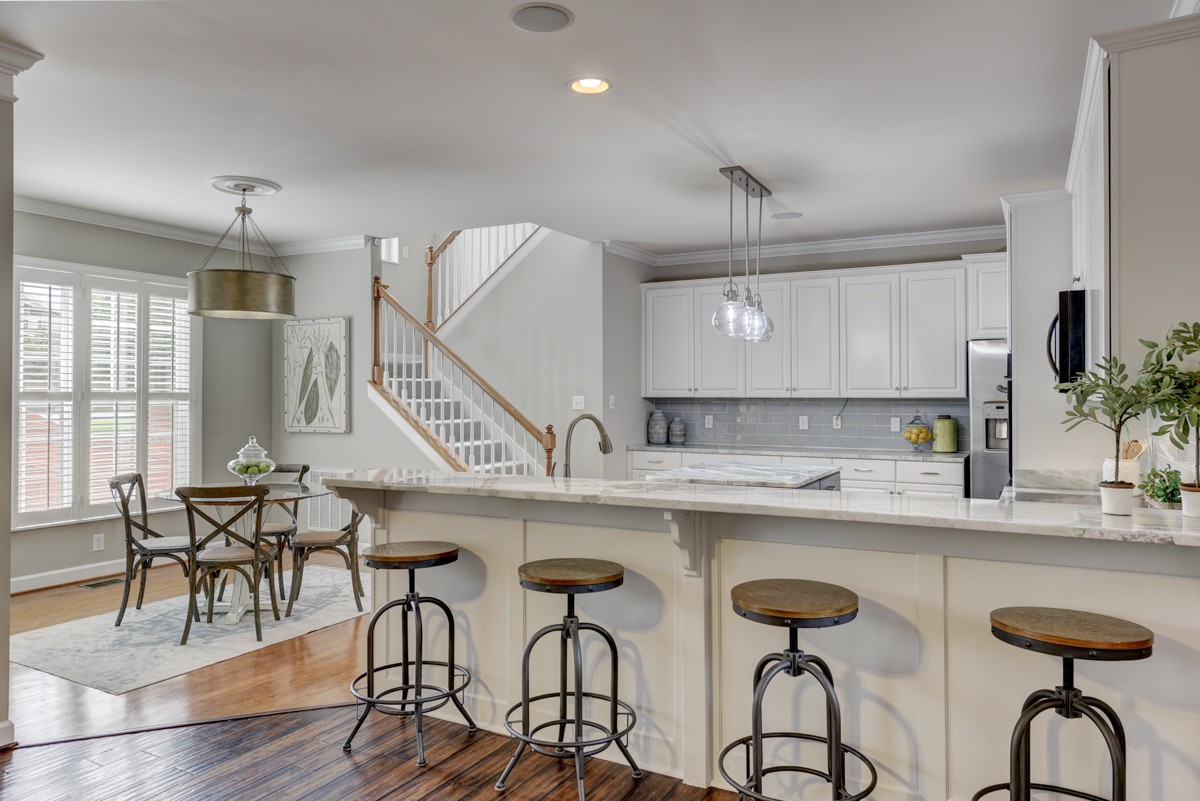 3008 Westerly Drive Franklin, TN 37067 - Photo 10 of 33 a kitchen with stainless steel appliances a white table chairs and a wooden floor