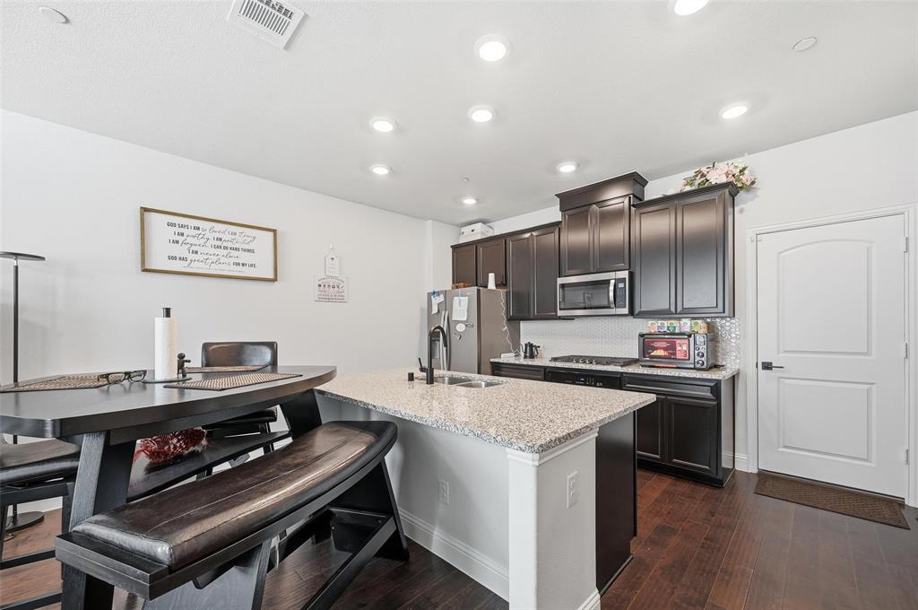 3544 Thistlewood Drive Plano, TX 75074 - Photo 17 of 24 a kitchen with kitchen island stainless steel appliances a sink a stove a refrigerator and a stove